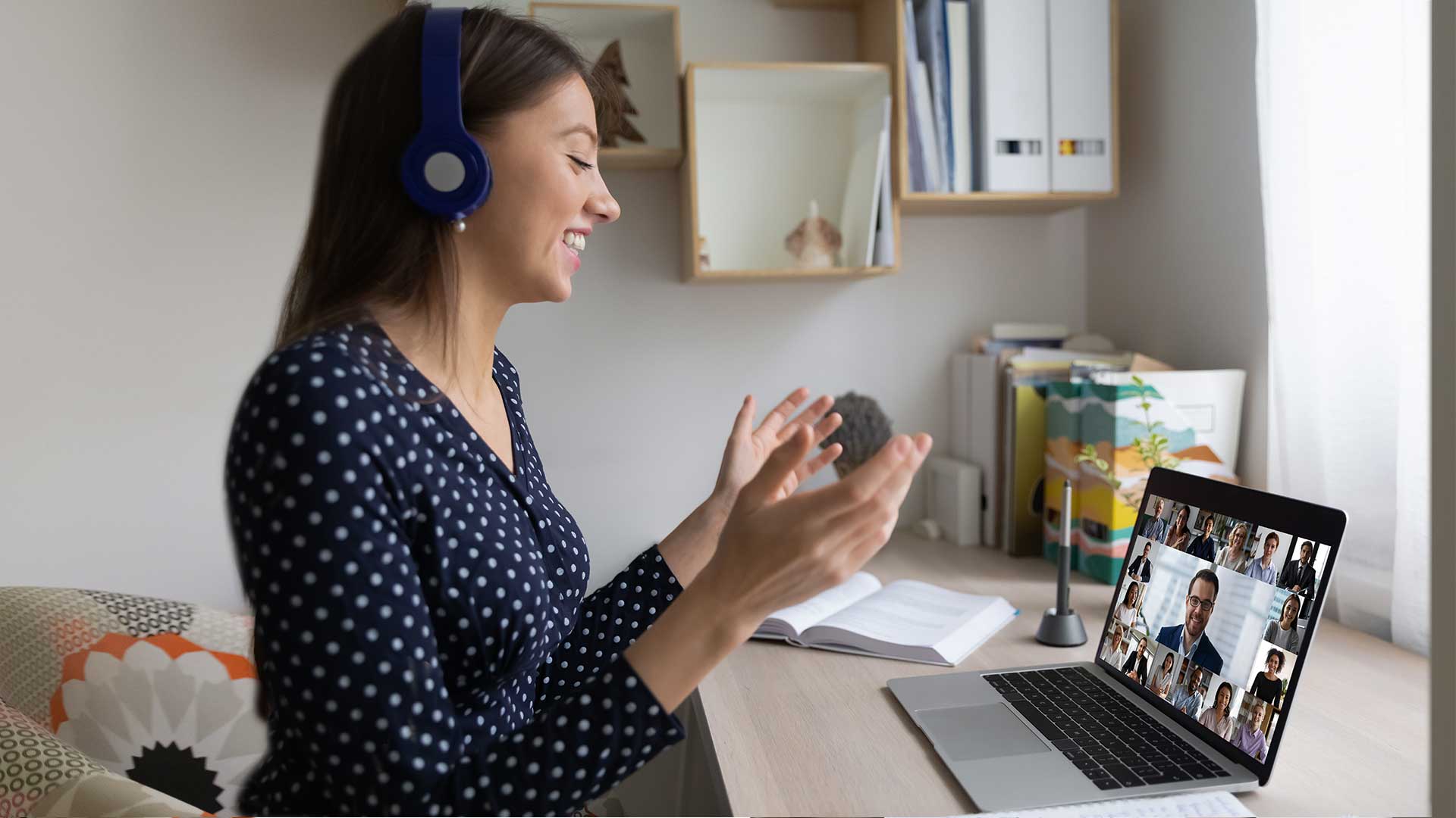 Adult wearing headphones, sitting in front of a desk with laptop open to an online training course.